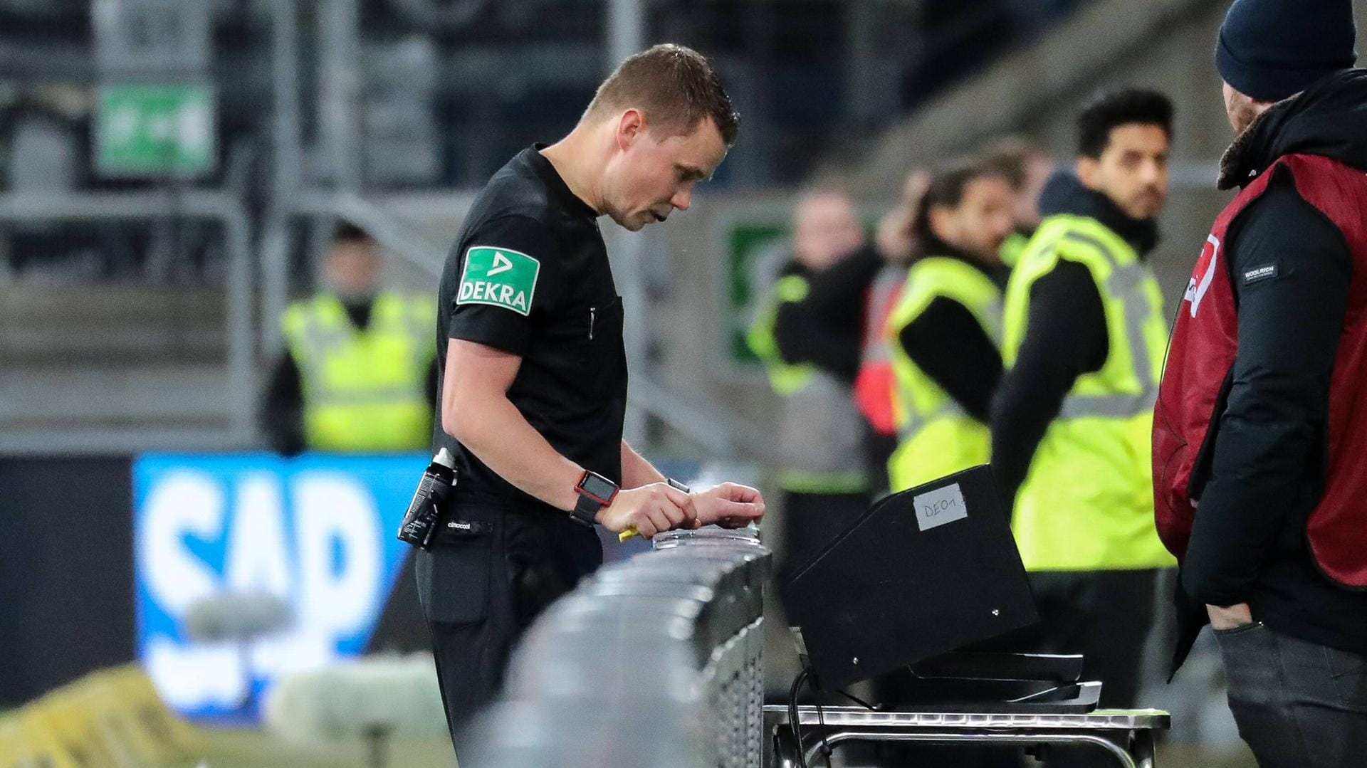 Schiedsrichter Dr. Robert Kampka konsultiert den Video-Assistenten am Spielfeldrand.