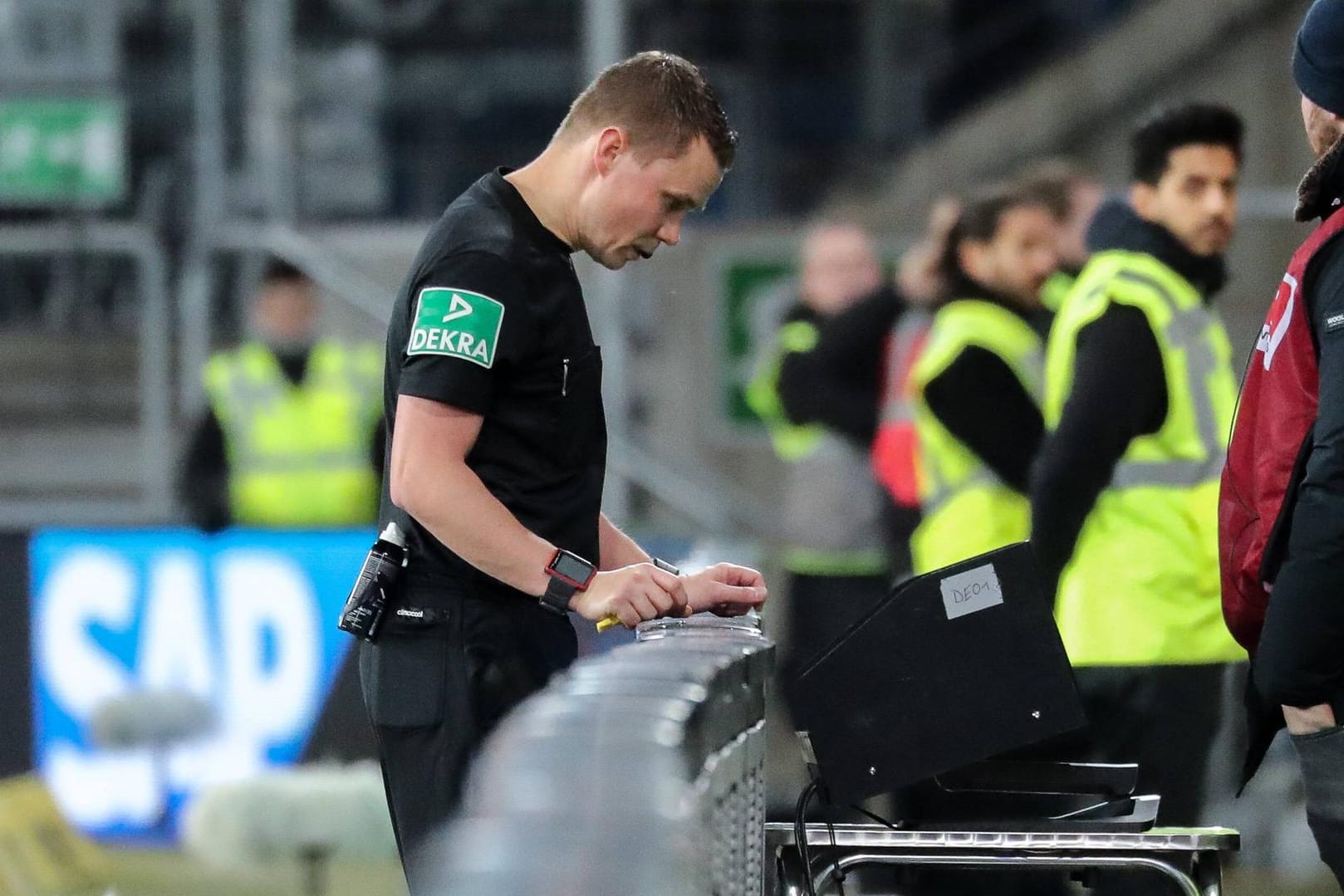 Schiedsrichter Dr. Robert Kampka konsultiert den Video-Assistenten am Spielfeldrand.