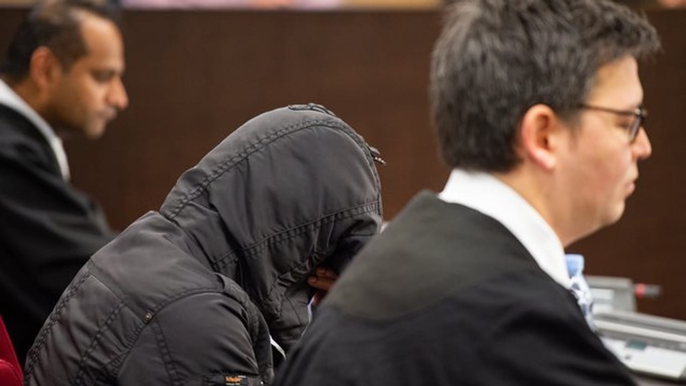 Der wegen Mordes an seiner siebenjährigen Tochter angeklagte Familienvater sitzt mit seinen Verteidigern im Düsseldorfer Landgericht.