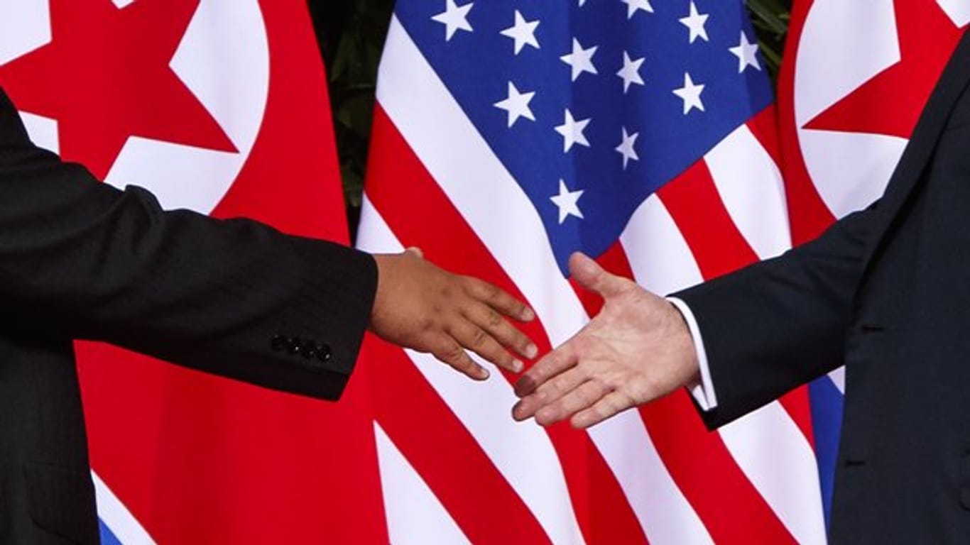 US Präsident Donald Trump (r) streckt dem nordkoreanischen Machthaber Kim Jong Un die Hand bei ihrem Treffen im Capella Resort auf der Insel Sentosa entgegen.