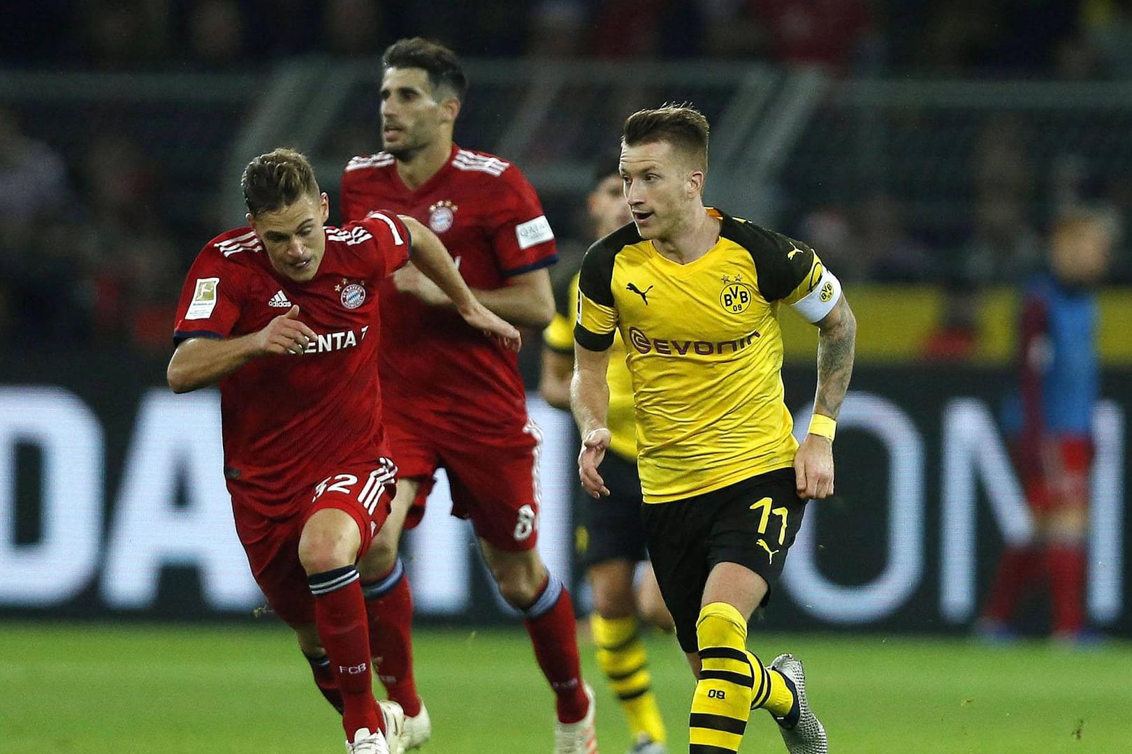 Marco Reus (gelb) im Laufduell mit Bayerns Joshua Kimmich.