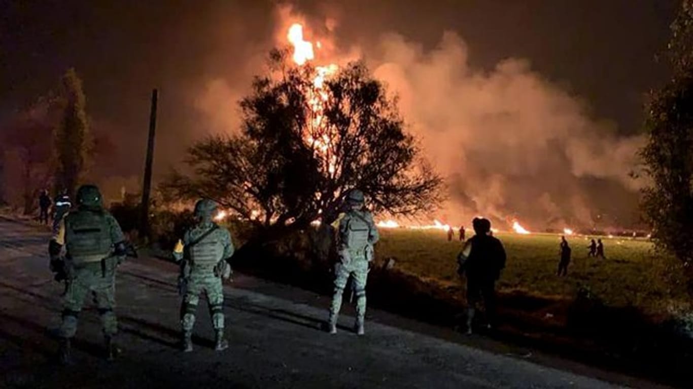 Streitkräfte der Armee sichern den Ort, an dem eine Benzinleitung explodiert ist.