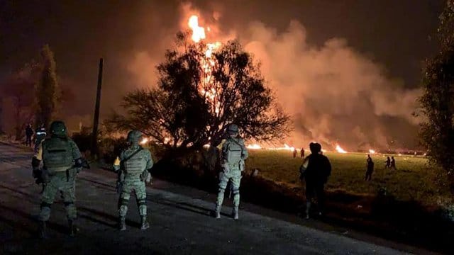 Streitkräfte der Armee sichern den Ort, an dem eine Benzinleitung explodiert ist. Streitkräfte der Armee sichern den Ort, an dem eine Benzinleitung explodiert ist.