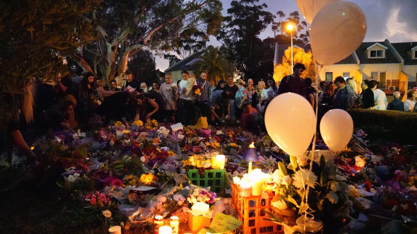 Menschen haben sich in der Nähe des Ortes, an der die Leiche einer getöteten Studentin gefunden wurde, versammelt und Blumen, Kerzen sowie Luftballons abgelegt.