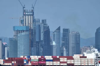 Ein Frachtschiff mit Containern ist vor der Skyline der chinesischen Stadt Qingdao zu sehen: Chinas Wirtschaft ist 2018 nur noch um 6,6 Prozent im Vergleich zum Vorjahr gewachsen.