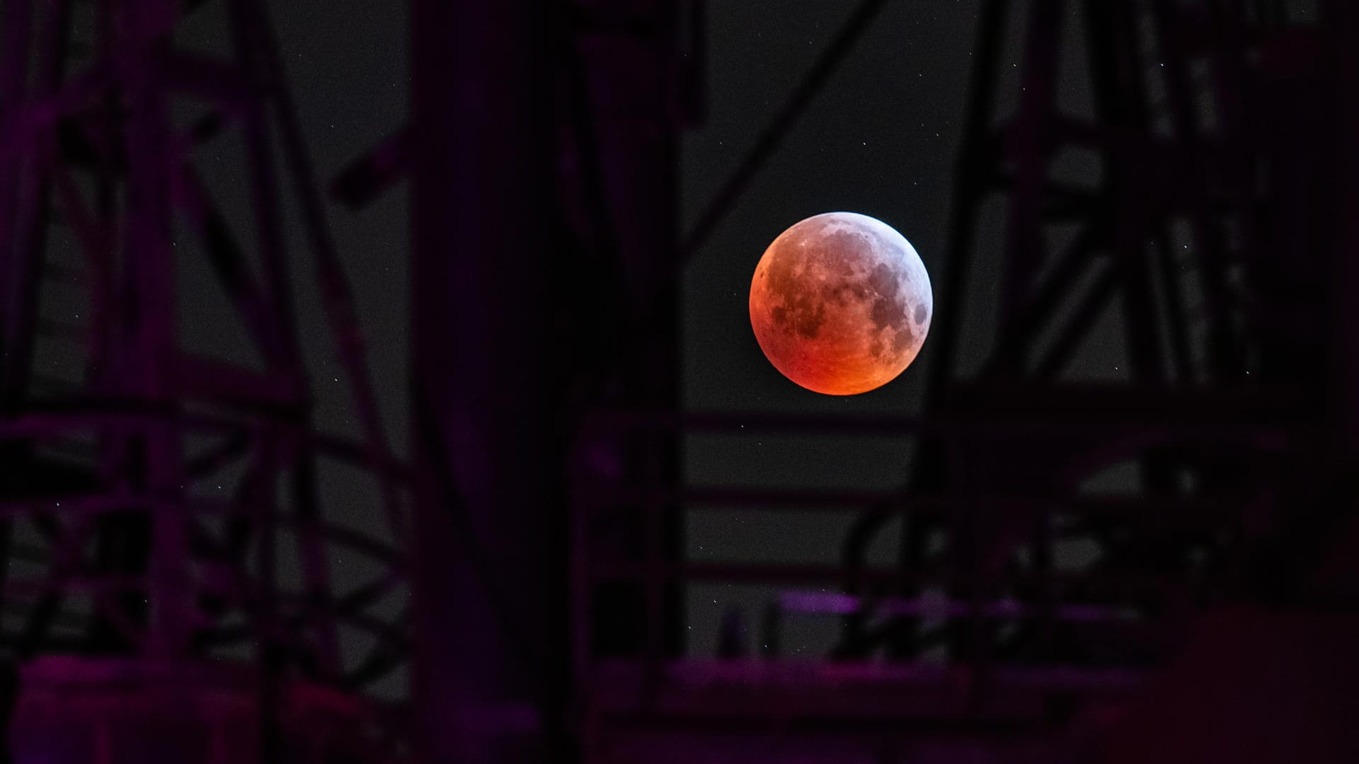 Als roter, sogenannter "Blutmond" präsentiert sich der Vollmond zwischen einer Industrieanlage im Landschaftspark Duisburg, während er in den Kernschatten der von der Sonnen angestrahlte Erde tritt. Der Kernschatten verdeckt dabei die sichtbare Oberfläche des Mondes. Mond, Sonne und Erde stehen genau in einer Linie.