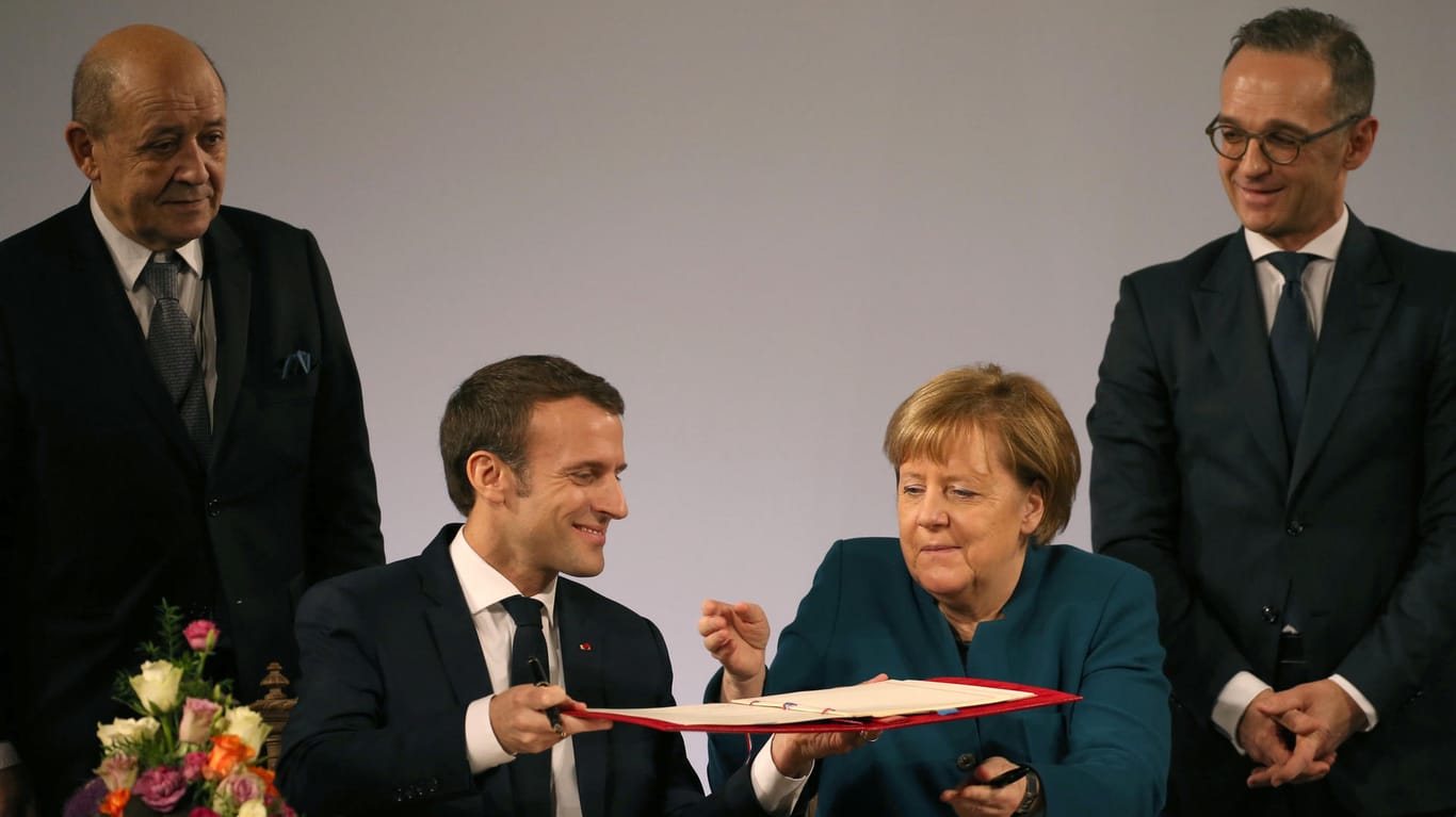 Frankreichs Präsident Emmanuel Macron, Bundeskanzlerin Angela Merkel, Jean-Yves Le Drian (l.), Außenminister von Frankreich, und Heiko Maas (r.): Der neue Vertrag ist unterzeichnet.