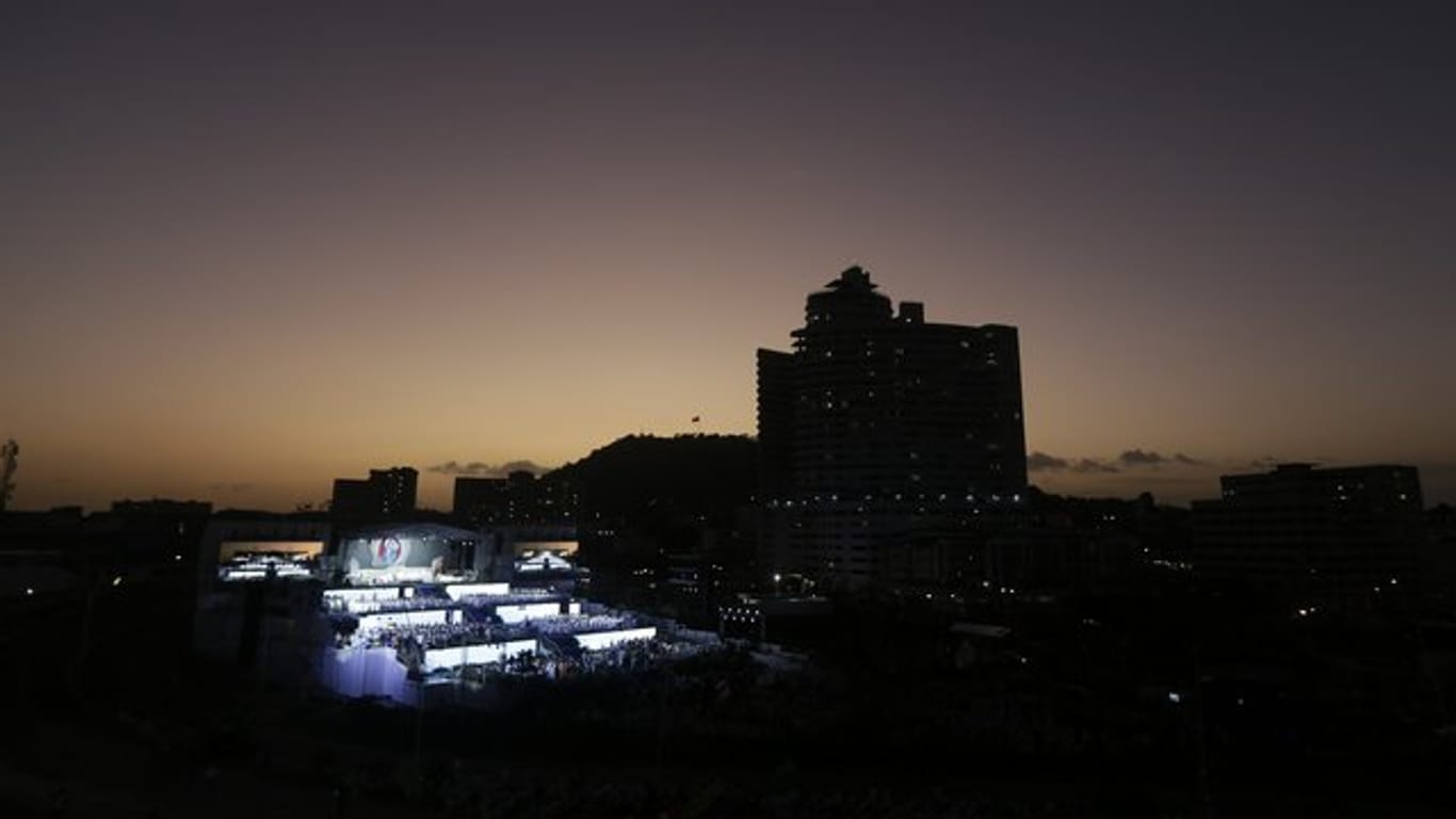 Pilger nehmen an der Eröffnungsfeier und Eröffnungsmesse in Panama-Stadt teil, während im Hintergrund die Sonne untergeht.