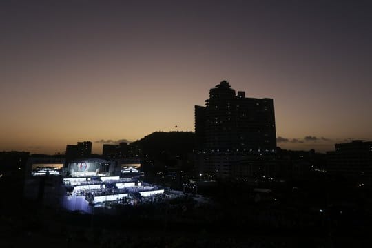 Pilger nehmen an der Eröffnungsfeier und Eröffnungsmesse in Panama-Stadt teil, während im Hintergrund die Sonne untergeht.