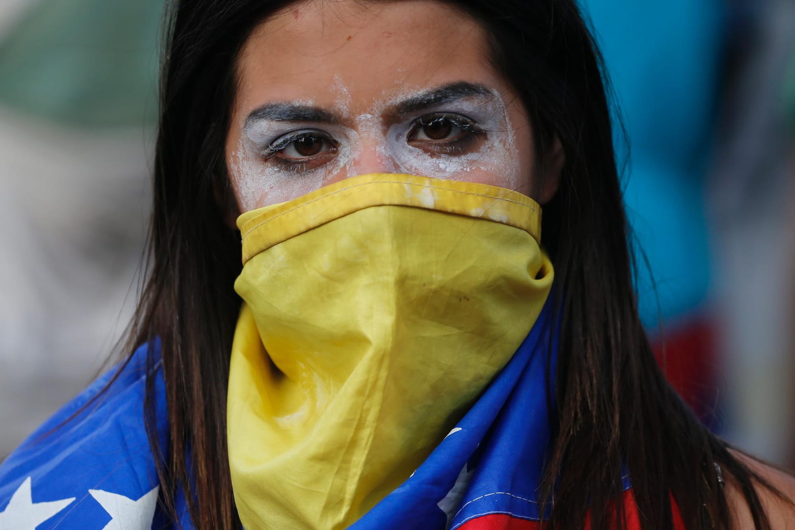 Demonstrantin in Caracas: Ihr Gesicht hat die junge Frau mit der venezolanischen Flagge umwickelt, um die Augen hat sie Zahnpasta geschmiert, um die Wirkung des Tränengases zu mindern.