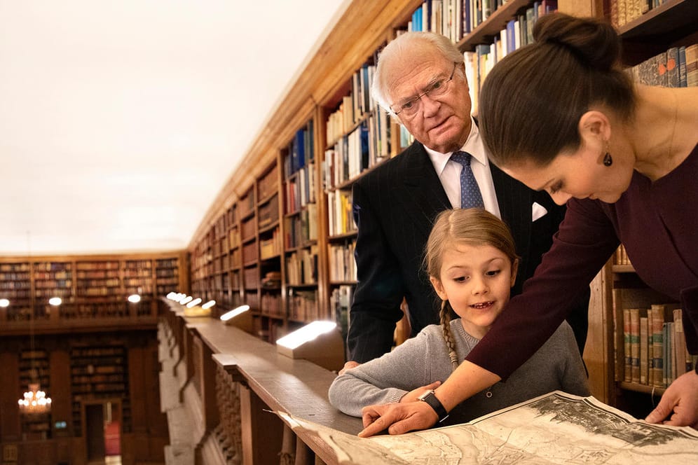 Drei Generationen: König Carl Gustaf, Prinzessin Estelle und Kronprinzessin Victoria besuchen die Bernadatto-Bibliothek.