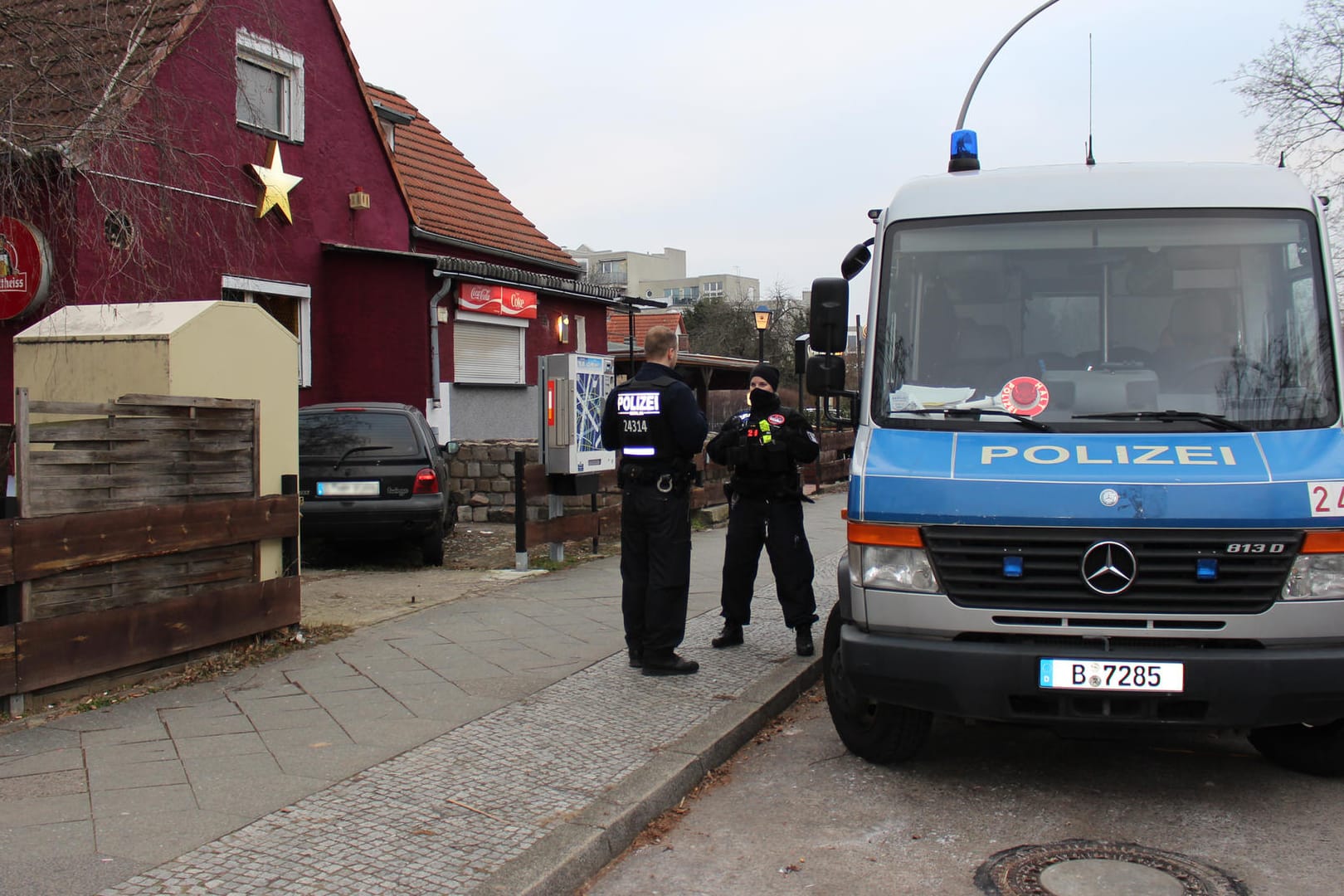 Polizisten vor einer Kneipe in Spandau: Bei der Durchsuchung mehrerer Objekte wurden zehn Verdächtige festgenommen.