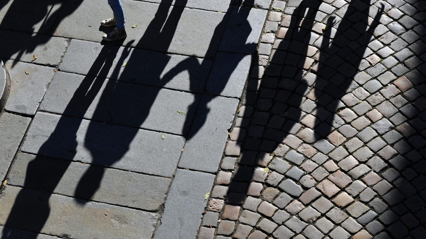 Eine Familie wirft lange Schatten auf einen Gehweg (Symbolbild): Die EU-Kommission geht gegen Österreichs neue Kindergeld-Regeln vor.