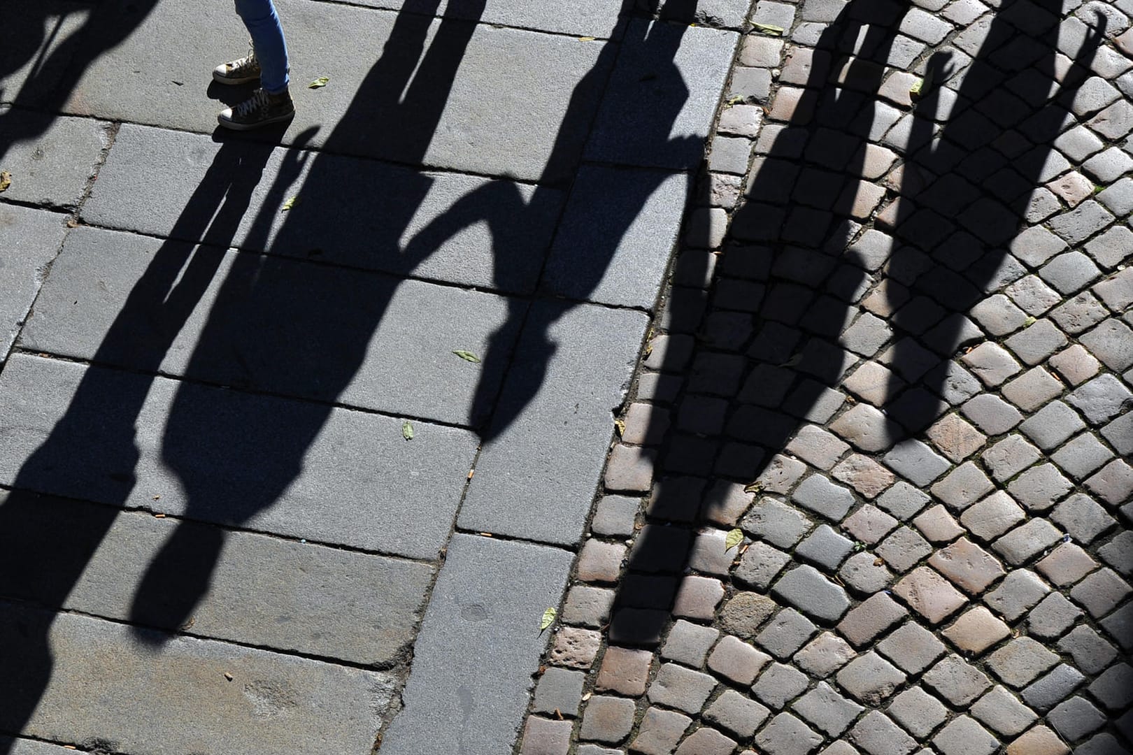 Eine Familie wirft lange Schatten auf einen Gehweg (Symbolbild): Die EU-Kommission geht gegen Österreichs neue Kindergeld-Regeln vor.