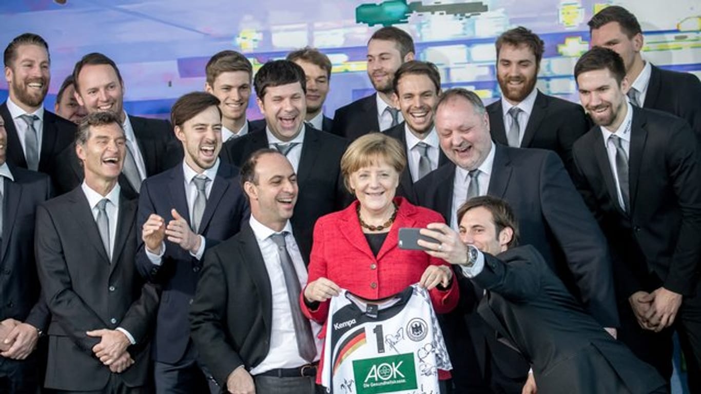 Bundeskanzlerin Angela Merkel posiert 2016 mit der deutschen Handball-Nationalmannschaft.