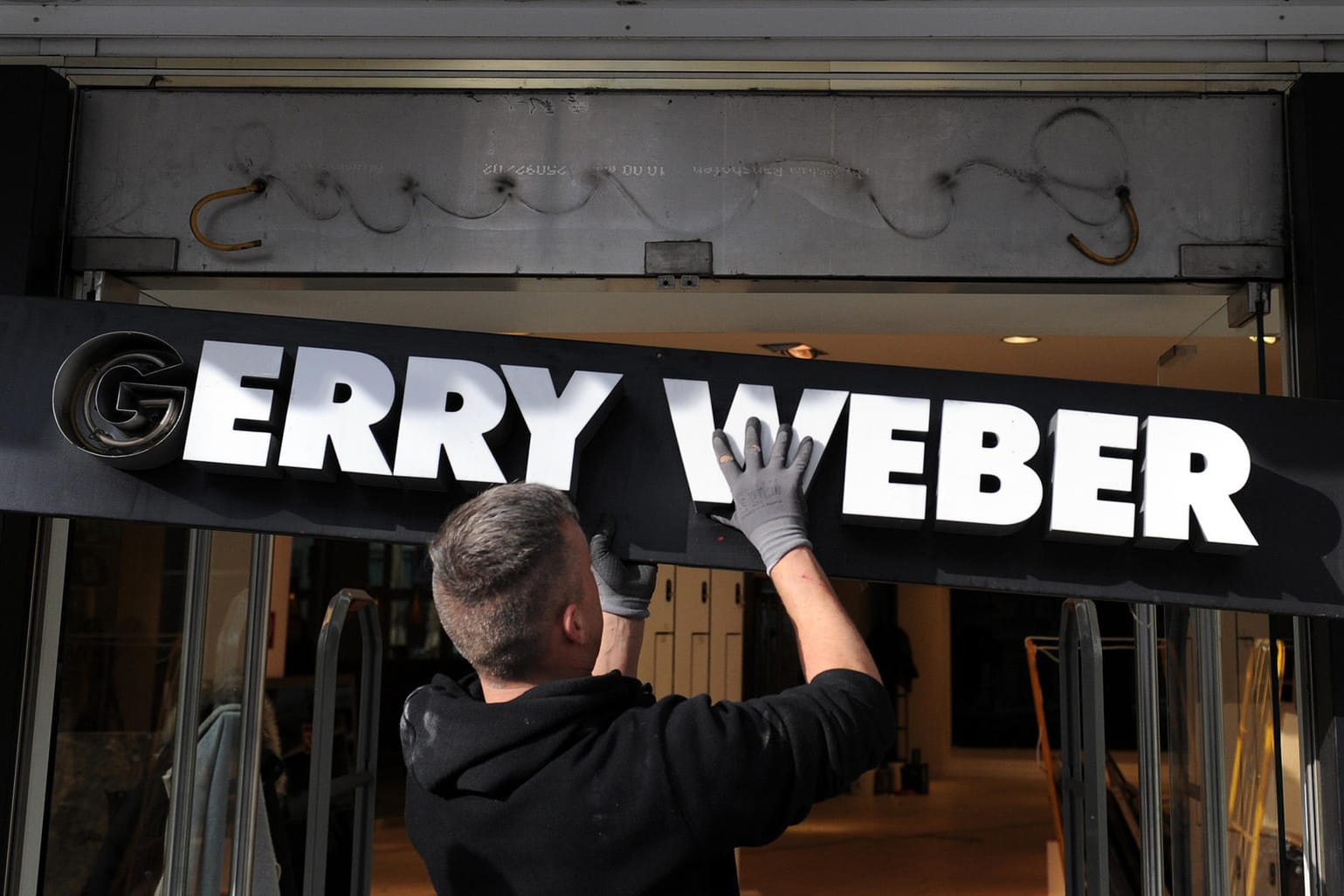 Schild mit dem Schriftzug "Gerry Weber": Der Geschäftsbetrieb soll vorerst weitergehen.