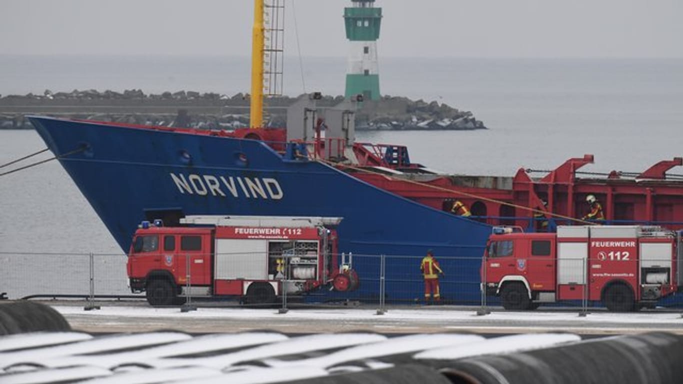 Fahrzeuge der Einsatzkräfte stehen vor dem havarierten Stückgutfrachter "Norvind" im Hafen Sassnitz-Mukran.