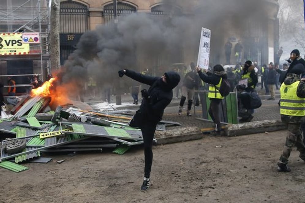 Ein Demonstrant in Paris bewirft die Polizei.