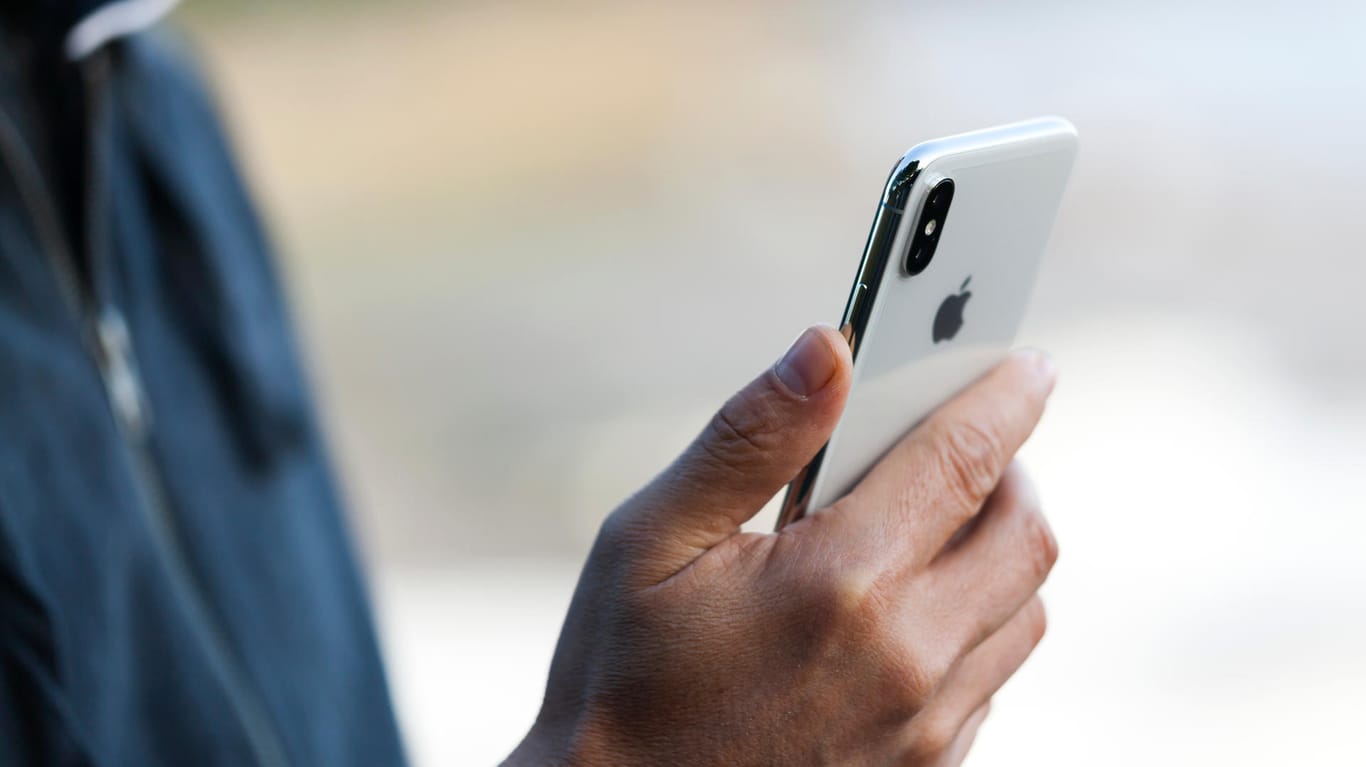Ein Mann mit einem iPhone X (Symbolbild): Eine Sicherheitslücke für iOS bedroht derzeit iPhone-Nutzer.