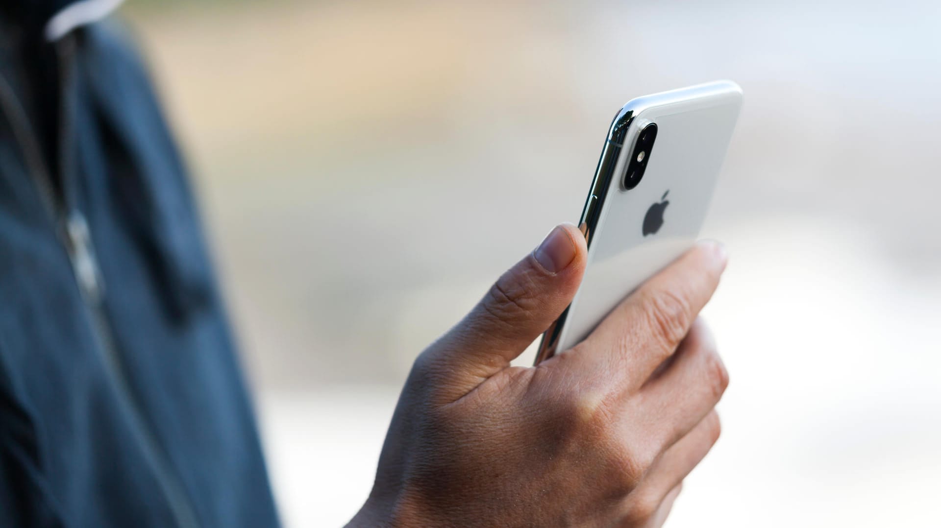 Ein Mann mit einem iPhone X (Symbolbild): Eine Sicherheitslücke für iOS bedroht derzeit iPhone-Nutzer.