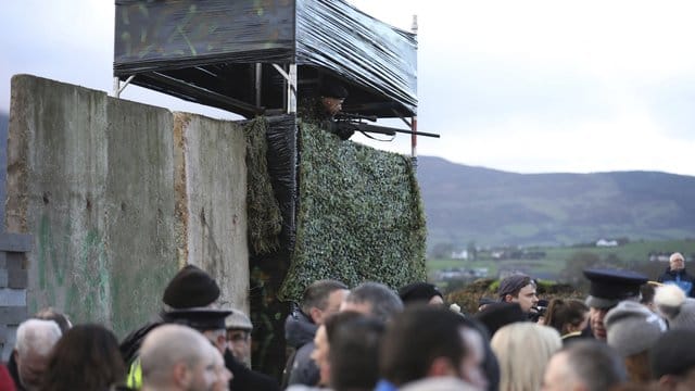 Ein als Soldat verkleideter Demonstrant steht auf einer Wachturm-Attrappe.
