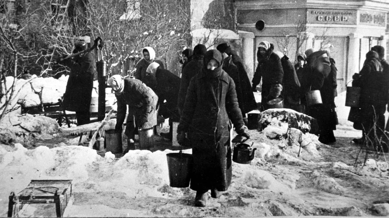 Während der Belagerung holen Bewohner Leningrads Trinkwasser von einem Hydranten.