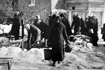 Während der Belagerung holen Bewohner Leningrads Trinkwasser von einem Hydranten.