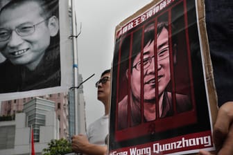 Demonstranten mit Plakaten des gestorbenen Friedensnobelpreisträgers Liu Xiaobo (links) und des inhaftierten Menschenrechtlers Wang Quanzhang: Der prominente chinesische Bürgerrechtsanwalt ist zu viereinhalb Jahren Haft verurteilt worden.