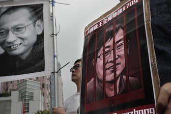 Demonstranten halten Plakate mit dem Bild des gestorbenen chinesischen Friedensnobelpreisträgers Liu Xiaobo (l) und des inhaftierten Menschenrechtlers Wang Quanzhang während einer Protestkundgebung im Juli 2018.
