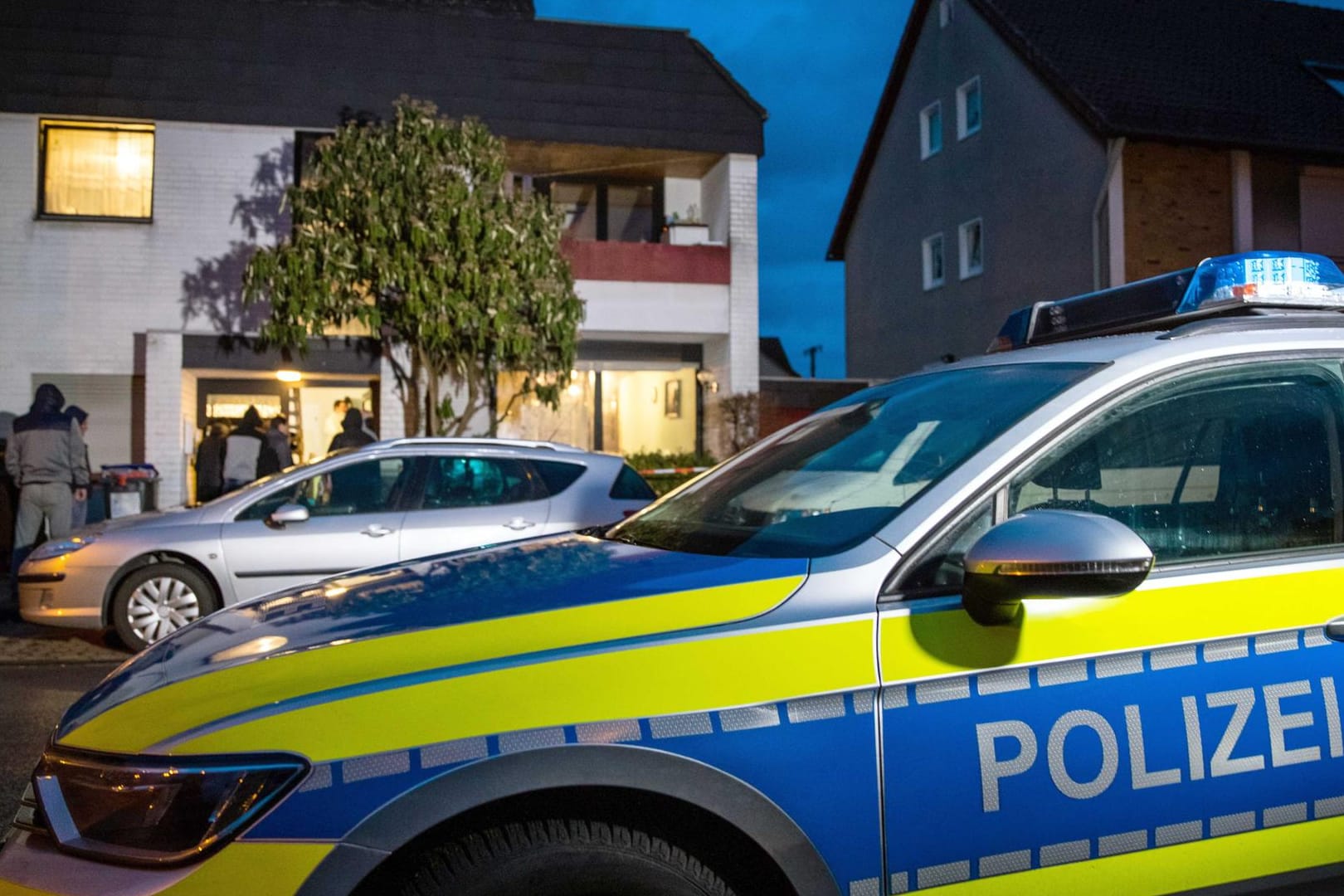 Ein Streifenwagen der Polizei parkt vor dem Mehrfamilienhaus in Lehrte: Ein 34 Jahre alter Mann ist hier tot aufgefunden worden.