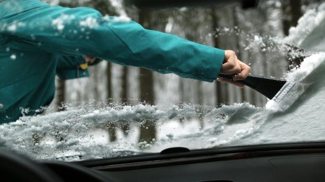 Kratzen ohne Kummer: Den Eiskratzer bewegen Autofahrer am besten immer vom Körper weg und arbeiten sich von oben nach unten vor.