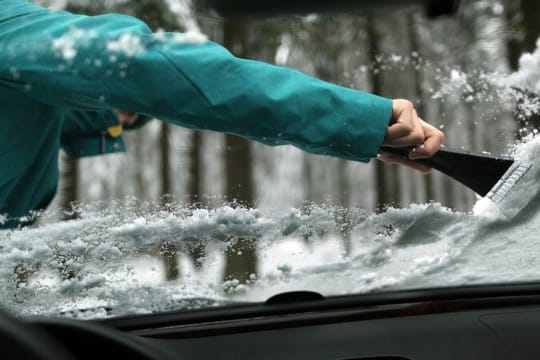 Kratzen ohne Kummer: Den Eiskratzer bewegen Autofahrer am besten immer vom Körper weg und arbeiten sich von oben nach unten vor.