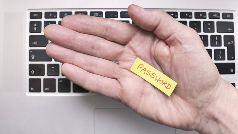 Eine Hand hält ein Notizzettel mit der Aufschrift "Password": Lange und komplizierte Kennwörter können in einem Passwortmanager gespeichert werden.
