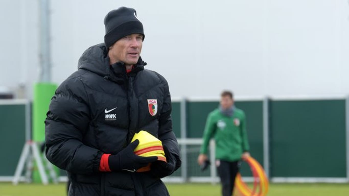 Co-Trainer Jens Lehmann trägt im Training des FC Augsburg Markierungshütchen.
