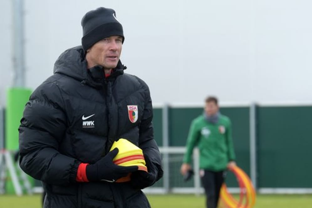 Co-Trainer Jens Lehmann trägt im Training des FC Augsburg Markierungshütchen.