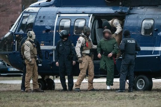 Polizisten führen einen mutmaßlichen Terrorverdächtigen aus einem Helikopter in Karlsruhe.