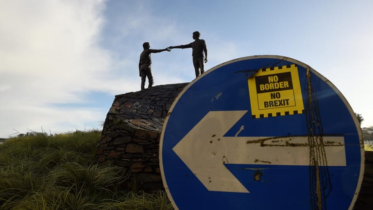 Verkehrschild mit 'No Border, No Brexit'-Aufkleber vor einer Friedensstatue in Nordirland: Mehrheit der Nordiren ist für den Backstop.