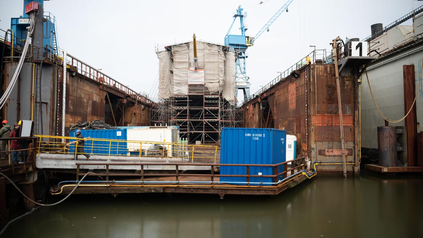 Ein Teil des Segelschulschiffs schaut im Dock unter Planen hervor: 10 Millionen sollte die Sanierung kosten – zuletzt waren es nun um die 135 Millionen. (Archivbild)