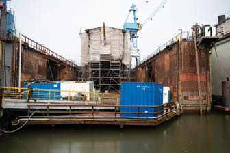 Ein Teil des Segelschulschiffs schaut im Dock unter Planen hervor: 10 Millionen sollte die Sanierung kosten – zuletzt waren es nun um die 135 Millionen. (Archivbild)