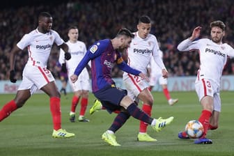 Bedrängt von gleich drei Gegenspielern des FC Sevilla kommt Barcelonas Lionel Messi (M) zum Schuss.