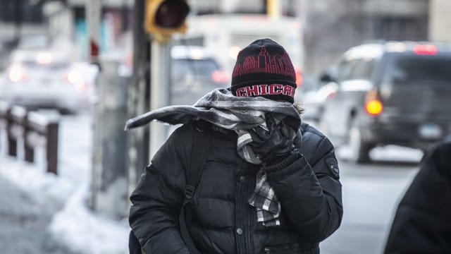 Dick eingepackt geht ein Mann am Morgen in Chicago zur Arbeit. Dick eingepackt geht ein Mann am Morgen in Chicago zur Arbeit.