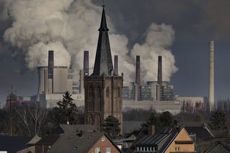 Rauch und Dampf steigen aus dem RWE Braunkohlekraftwerk Neurath hinter der St.