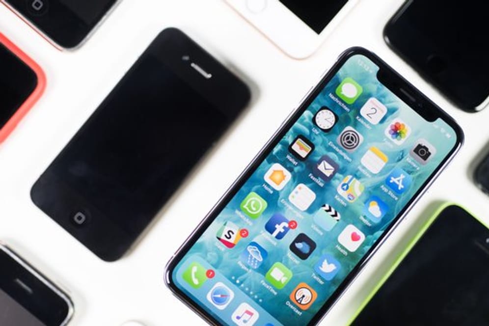 Ein iPhone X liegt neben iPhones anderer Generationen auf einem Tisch.
