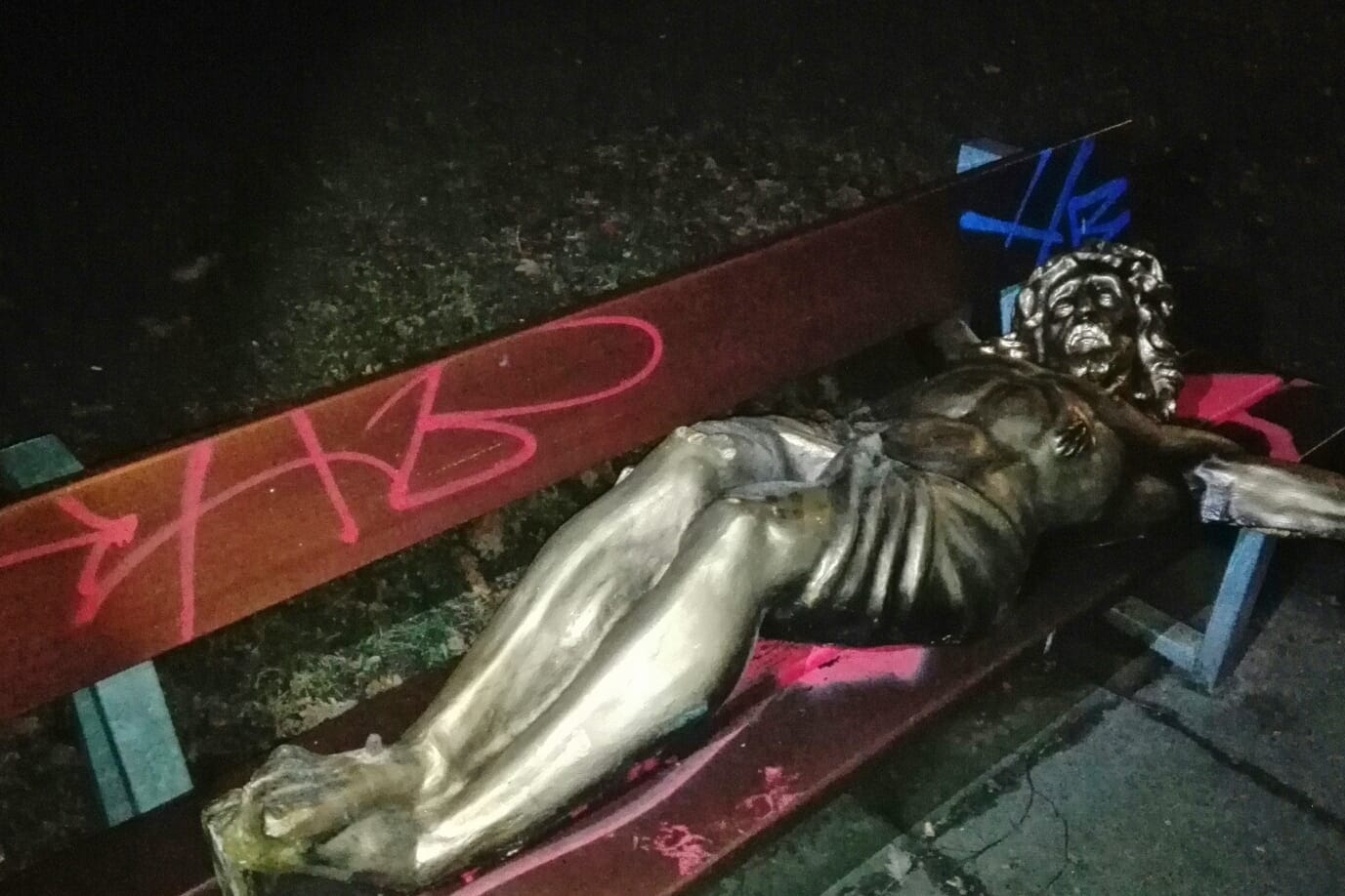 Goldene Jesusfigur auf Parkbank
