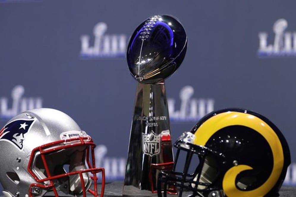 Die Helme der New England Patriots (l) und Los Angeles Rams und die Vince Lombardi Trophy.