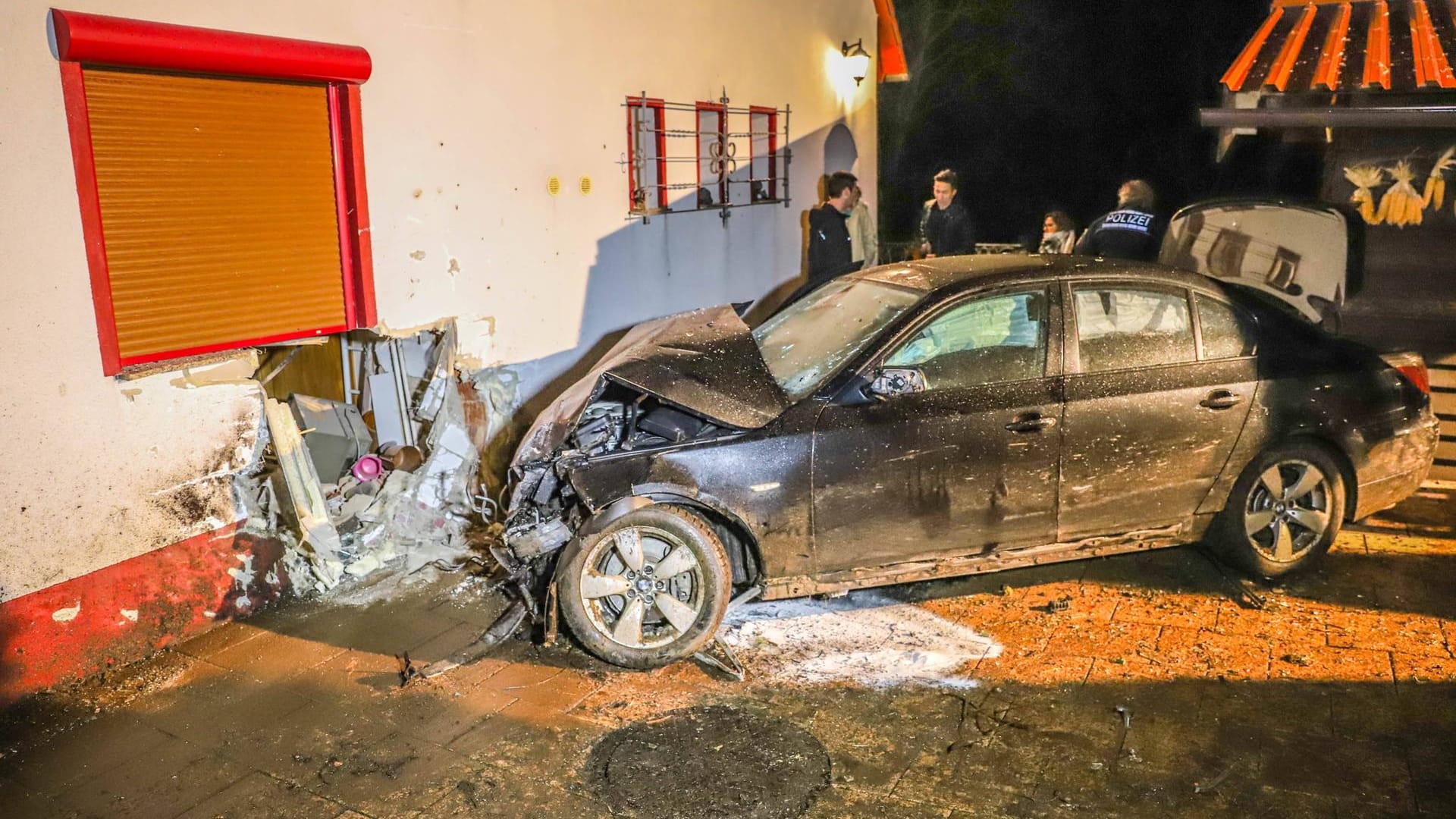 Der Unfallwagen vor dem verursachten Loch in der Hauswand: Bevor er in der Küche zum Stehen kam, hatte der junge Mann auch noch ein benachbartes Gewächshaus durchfahren.