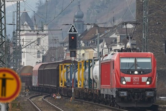 Ein Güterzug fährt unmittelbar an den Häusern der Altstadt von Kaub vorbei.