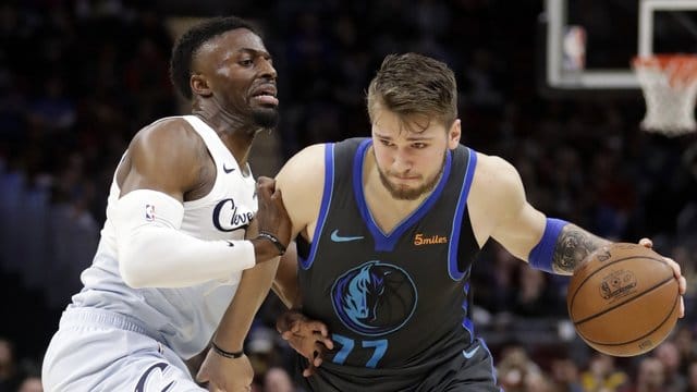 Luka Doncic (r) von den Mavericks kann sich gegen David Nwaba von den Cleveland Cavaliers durchsetzen.