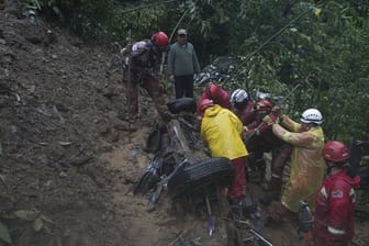 Feuerwehrleute versuchen nach einer Schlammlawine in Bolivien Opfer aus einem Auto zu retten.