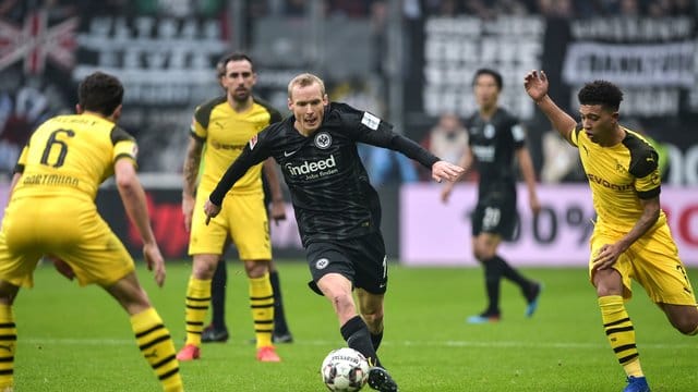 Frankfurts Sebastian Rode (M) versucht mit dem Ball zwischen den Dortmundern Thomas Delaney (l) und Jadon Sancho hinduch zu kommen. Frankfurts Sebastian Rode (M) versucht mit dem Ball zwischen den Dortmundern Thomas Delaney (l) und Jadon Sancho hinduch zu kommen.
